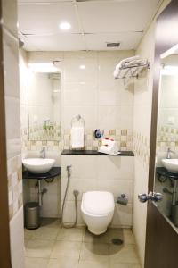 a bathroom with a toilet and two sinks at Blue Ocean Residency in Bangalore