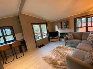 a living room with a couch and a table at L19 - Penrhyn Spa Lodge with Hot Tub in Bethesda