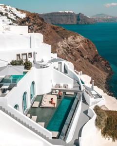 a large white boat sitting on top of a cliff at Echoes Luxury Suites in Oia