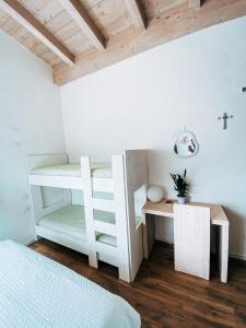 a bedroom with a white bunk bed and a desk at AGRITURISMO DAL PEROTIN in Caldonazzo