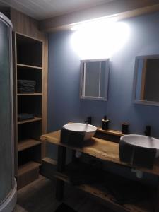 a bathroom with two sinks on a wooden counter at Le chant de l Aisne in Érezée