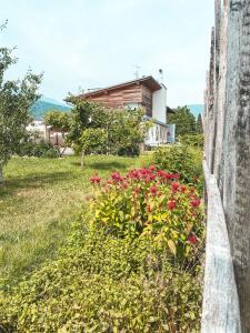 a retaining wall with flowers in front of a house at AGRITURISMO DAL PEROTIN in Caldonazzo
