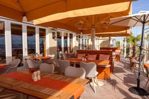 an outdoor patio with tables and chairs and umbrellas at Roslin Beach Hotel in Southend-on-Sea