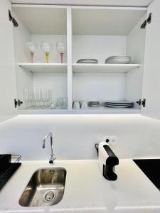 un bancone della cucina con lavandino e bicchieri sugli scaffali di Loft City Center Viana a Viana do Castelo
