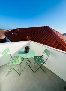dwa krzesła i stół na balkonie w obiekcie Loft City Center Viana w mieście Viana do Castelo