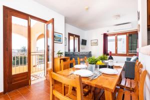 Il comprend une cuisine et une salle à manger avec une table et des chaises en bois. dans l'établissement Villa Matias Maria by Villa Plus, à Cala en Blanes