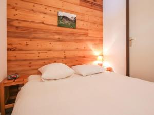 een slaapkamer met een wit bed en een houten muur bij Appartement La Rosière, 2 pièces, 6 personnes - FR-1-275-170 in La Rosière