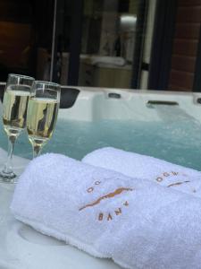 a towel and two glasses of wine on a table at P74 - Riverside Family Pod with Hot Tub in Bethesda