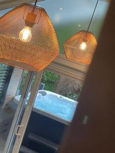 two lights hanging from a window next to a tub at P74 - Riverside Family Pod with Hot Tub in Bethesda