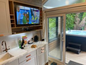 a kitchen with a tub and a tv in a caravan at P74 - Riverside Family Pod with Hot Tub in Bethesda
