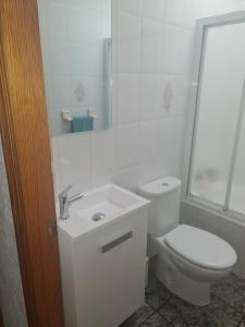 a white bathroom with a toilet and a sink at Apartamento Mari in Agua Amarga