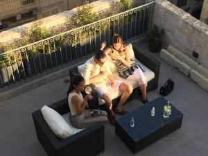 een groep van drie personen zittend op een bank bij The Coleridge Boutique Hotel In Valletta in Valletta