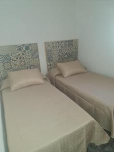 2 Betten in einem kleinen Zimmer mit ermottermottermott in der Unterkunft Apartamento Mari in Agua Amarga