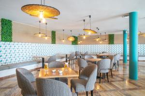 a restaurant with tables and chairs in a room at Hotel Menorca Binibeca - Adults Recommended - by Pierre & Vacances Premium in Binibeca