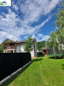 a house with a fence in front of a yard at Casa Mi&Ra in Lepşa