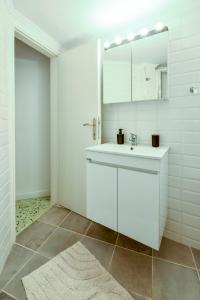 Un baño blanco con lavabo y espejo. en Thessaloniki Center Comfortable Apartment, en Tesalónica 102 fotos más