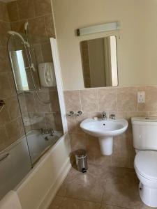 a bathroom with a sink and a toilet and a shower at Dunkerron Woods Holiday Homes in Kenmare +26 photos
