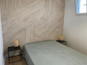 a bedroom with a wooden accent wall and a bed at Superbe appartement La Rochelle in La Rochelle