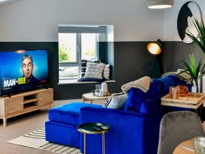 a living room with a blue couch and a tv at Pass the Keys Perfectly located stylish 2 bed home with Parking in Newport