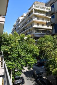un gran edificio de apartamentos con coches aparcados en un aparcamiento en Thessaloniki Center Comfortable Apartment, en Tesalónica