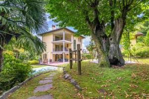 a house with a tree and a sign in front of it at Lake View Camelia Room at Villa Isabella Stresa Retreat Ages 6 plus in Stresa