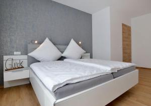 a bedroom with a large white bed with white pillows at Ferienwohnungen Am Aller-liebsten in Düngenheim