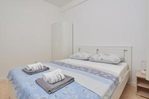 a bedroom with a bed with towels on it at Apartman Anastazije in Solin