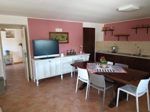 uma cozinha com uma mesa, uma televisão e uma sala de jantar em Casa Vacanze Nino Petrelli em Naso