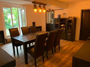 a dining room with a wooden table and chairs at la petite Poyannaise in Poyanne