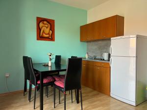 a kitchen with a black table and a white refrigerator at Apartmani Kacola in Tučepi