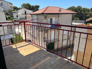 a balcony with a red railing next to a building at Apartmani Kacola in Tučepi
