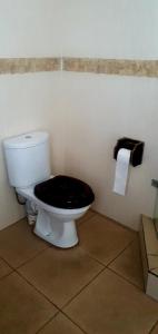 a toilet with a black seat in a bathroom at Sun view in Nelspruit