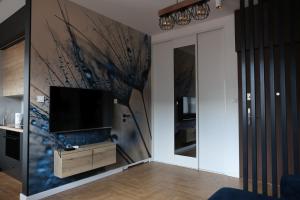 a living room with a flat screen tv on a wall at Apartament Hetman in Zamość