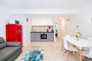 a living room with a red refrigerator and a table at Eldon Chambers Flat 1 by City Living London in London