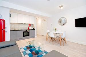 a kitchen and living room with a table and chairs at Eldon Chambers Flat 1 by City Living London in London