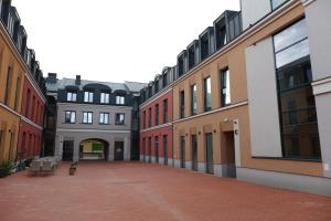 an empty courtyard of a building with red and white buildings at Apartament Hetman in Zamość