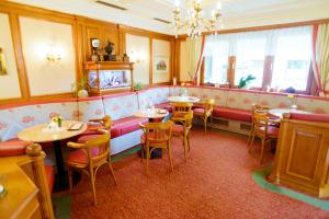 ハウス・イム・エンスタールにあるDorf Caféのテーブルと椅子、シャンデリアのあるレストラン