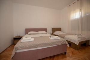 2 aparte bedden in een kamer met 2 tafels bij Apartman Luka&Petar in Trebinje
