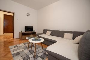 een woonkamer met een bank en een tafel bij Apartman Luka&Petar in Trebinje