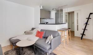 a living room with a gray couch and a table at Appartement de Standing Aux Portes de Paris in Nogent-sur-Marne +12 photos