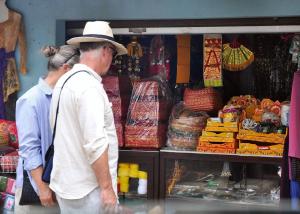 Un hombre y una mujer de pie frente a un puesto de comida. en Meme Surung Guesthouse, en Munduk
