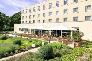 a hotel with tables and chairs in front of a building at Mercure Hotel Mannheim am Rathaus in Mannheim