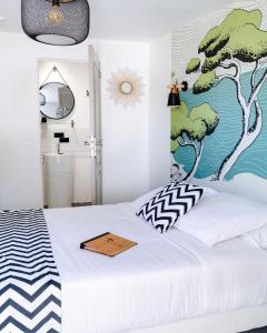 a bedroom with a bed with a mural on the wall at HôTEL LES VOLETS ROUGES - CASSIS in Cassis