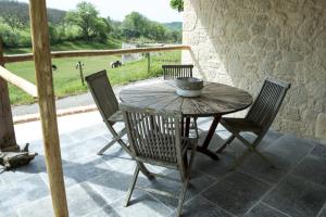 - une table et des chaises en bois sur une terrasse avec vue dans l'établissement Chapel Cottage, à La Bachellerie