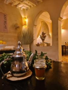 einen Wasserkocher und ein Getränk auf dem Tisch in der Unterkunft Riad Casa Sophia in Marrakesch + 37 Fotos