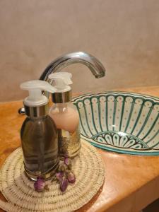 eine Flasche Seife und eine Schüssel auf dem Tisch in der Unterkunft Riad Casa Sophia in Marrakesch