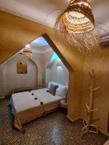 Schlafzimmer mit einem Bett und einem Kronleuchter in der Unterkunft Riad Casa Sophia in Marrakesch
