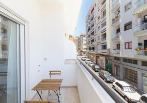 einen Balkon mit einem Tisch und Stadtblick in der Unterkunft Moderno apartamento urbano en barrio histórico 2ºI in Santa Cruz de Tenerife