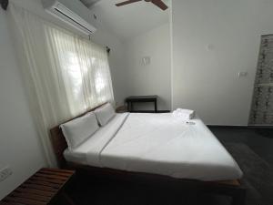 a bedroom with a large white bed with a window at Cheerful 2-Bedroom Villa with Private Plunge Pool, Candolim, Goa in Marmagao +17 photos