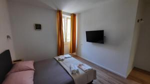 um quarto com uma cama e uma televisão de ecrã plano em Cherry em Split